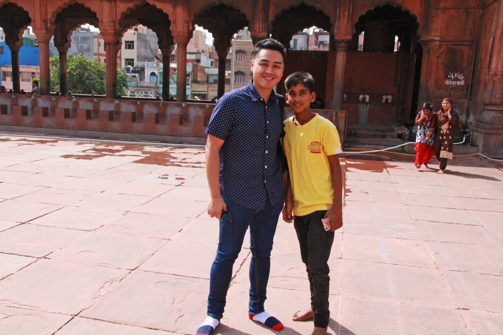 local-kid-asking-tourist-take-picture-jama-masjid-mosque-delhi-india